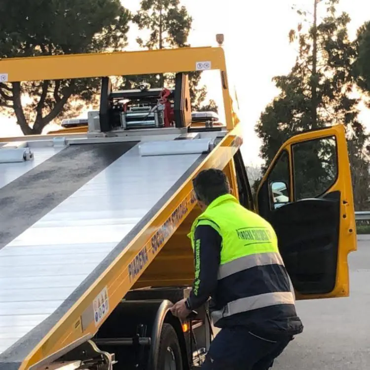 Operatore accanto al pianale inclinato del carro attrezzi