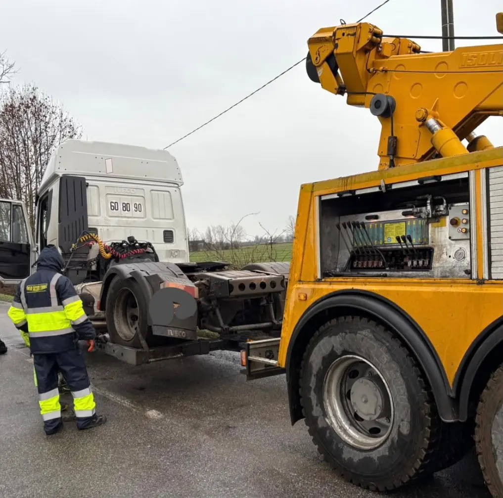 Operatore e gru durante il recupero di un trattore stradale
